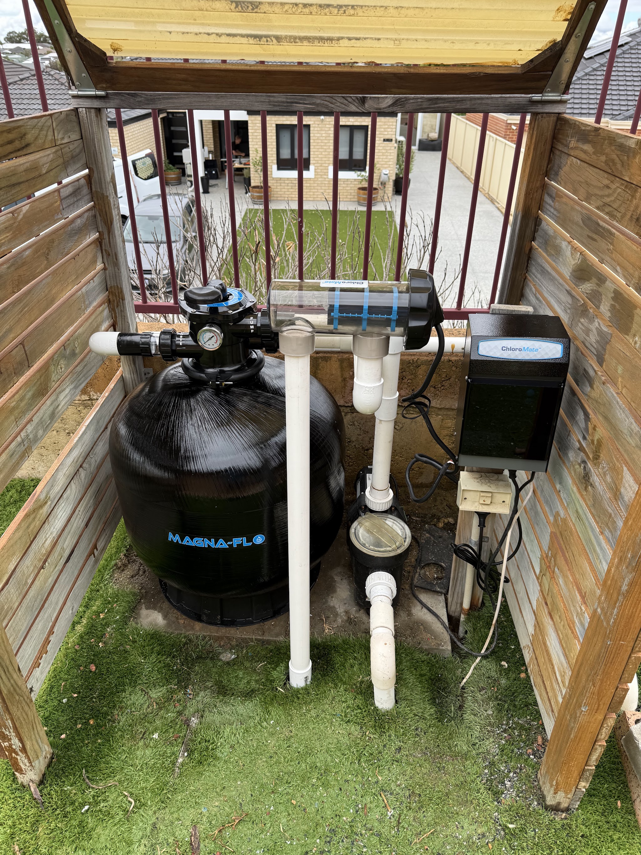 A sand filter and salt chlorinator installed in a timber equipment enclosure